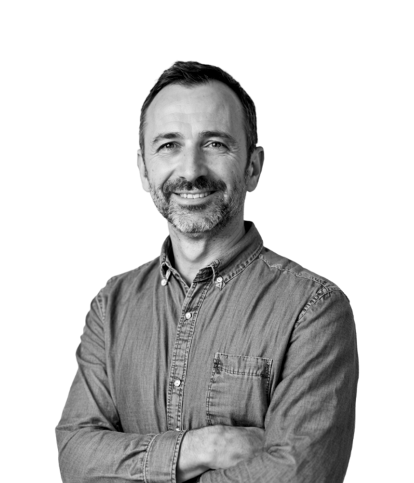 Black and white photo of a smiling, bearded professional man in a button-down shirt. Black and white photo of a smiling, bearded professional man in a button-down shirt on a purple gradient background. Text: 'Employers: Partnering with Game Studios & Growth-Focused Teams'.