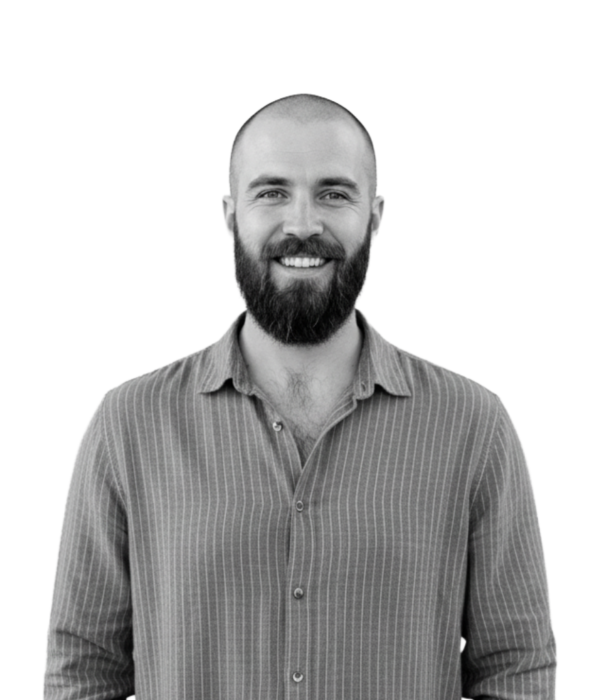 Black and white photo of a smiling professional man with a beard in a button-down shirt. Black and white photo of a smiling professional man with a beard in a button-down shirt. Text: 'Employers: Partnering with Game Studios & Growth-Focused Teams'.